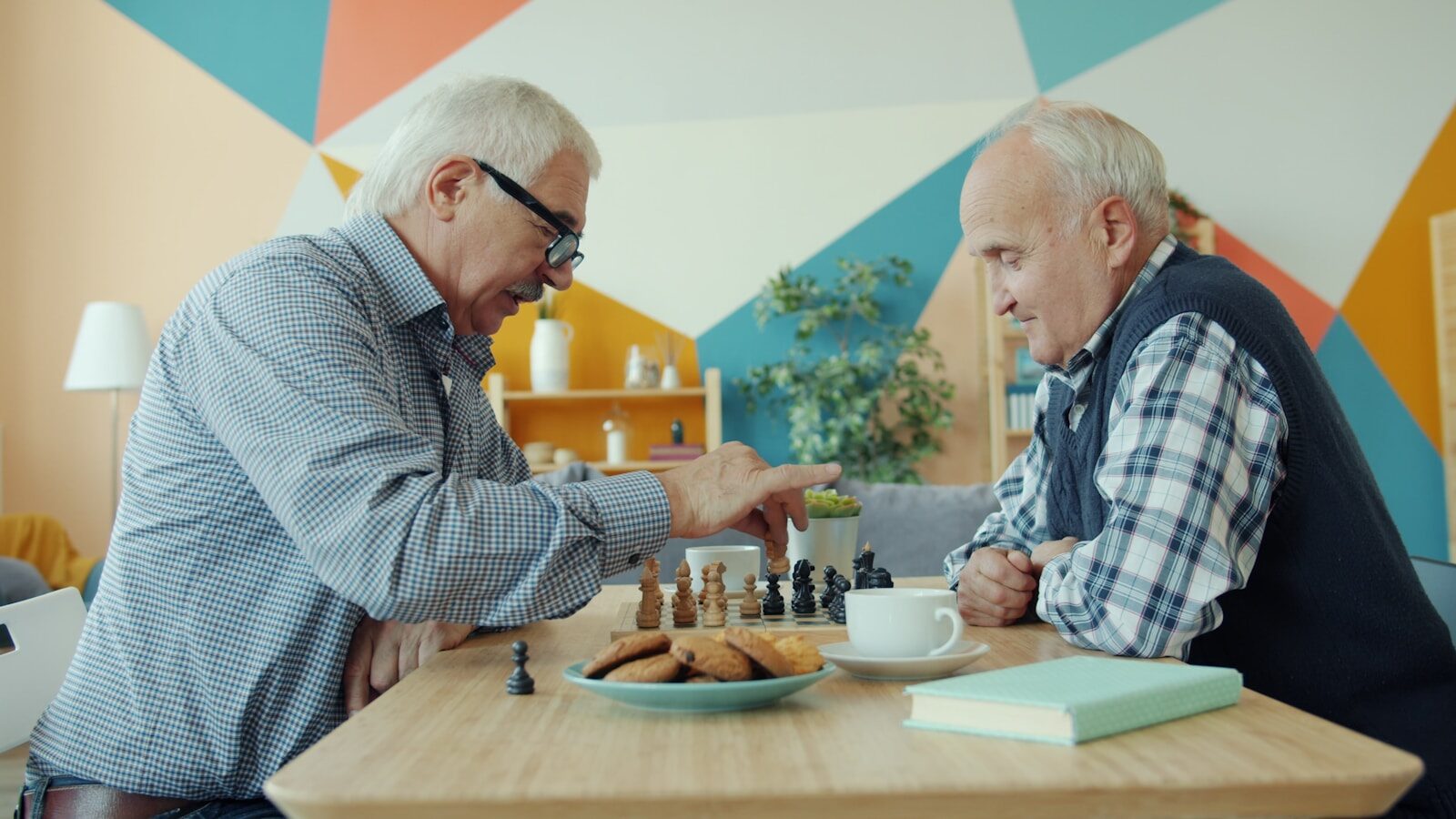 Two elderly men playing chess at a table. relacionada a Aposentadoria da pessoa com deficiência: requisitos e cuidados