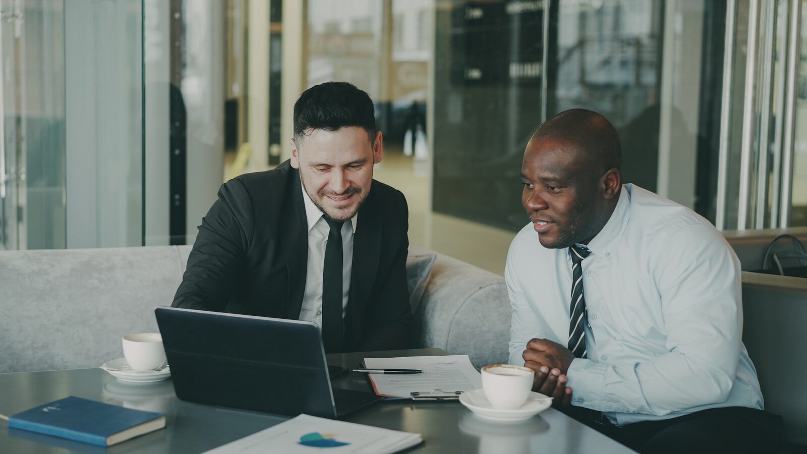 Two businessmen collaborating on a laptop. relacionada a O que um advogado pode e não pode prometer no INSS