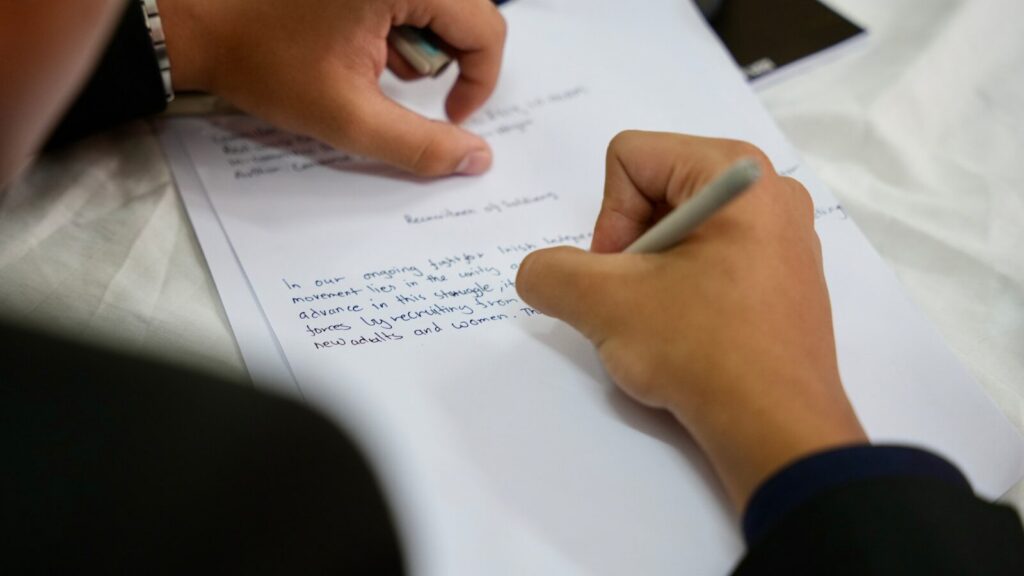 A person writing on a piece of paper