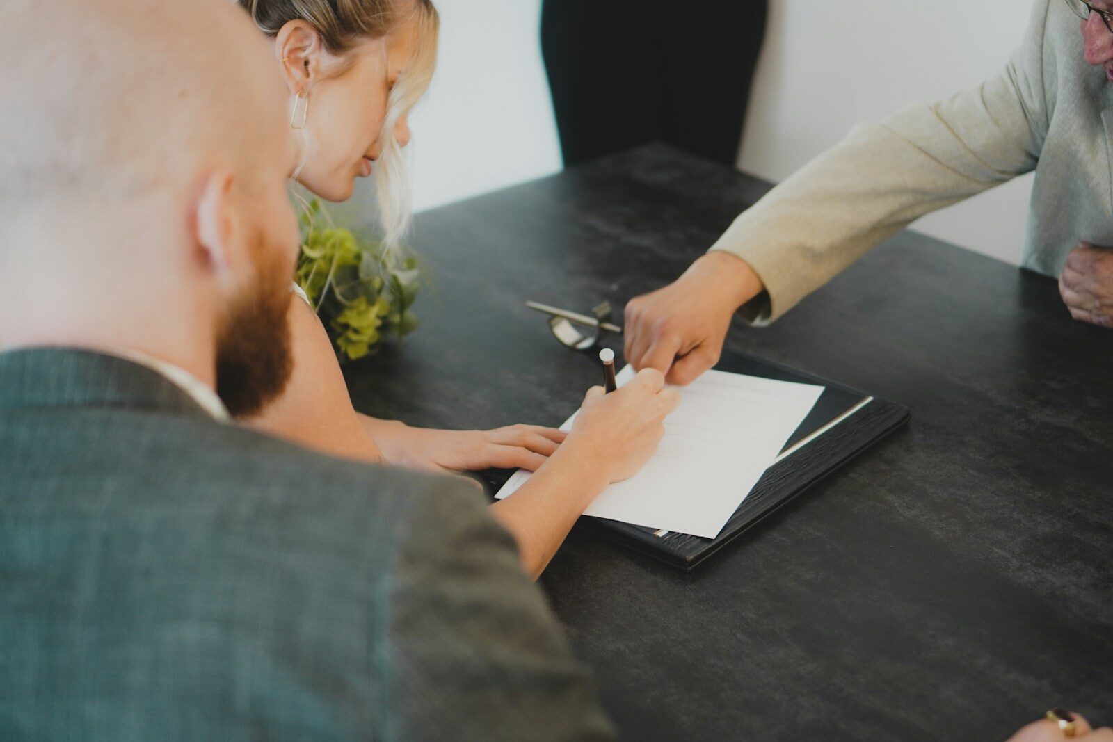 couple signing document at desk relacionada a O que um advogado pode e não pode prometer no INSS